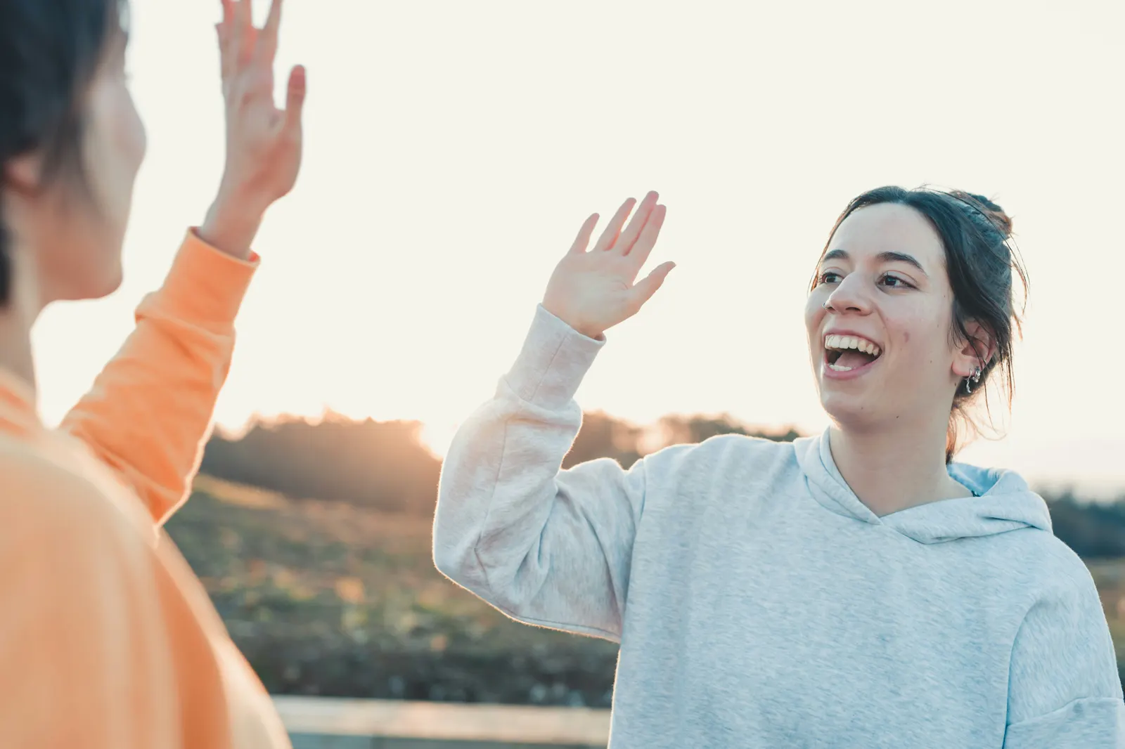 Two women high-fiving in a supportive moment